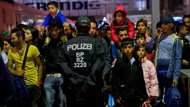 Eine Menschenmenge steht hinter einem Polizisten.