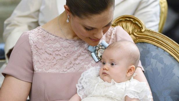 Kronprinzessin Victoria hält ein Baby im Arm.