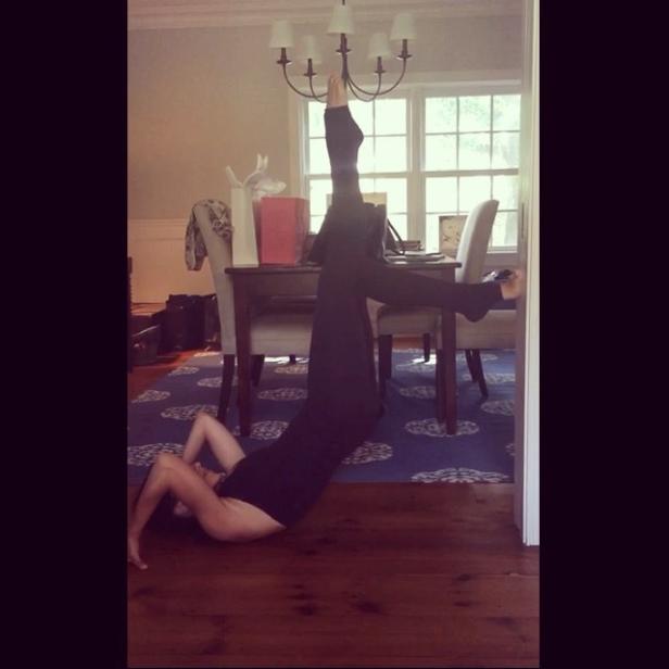 Eine Frau macht eine Yoga-Übung in einem Wohnzimmer.
