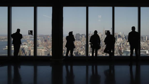 Silhouetten von Menschen vor der Skyline von New York City.