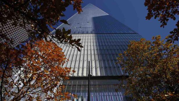 Das One World Trade Center in New York, gesehen durch herbstliche Bäume.