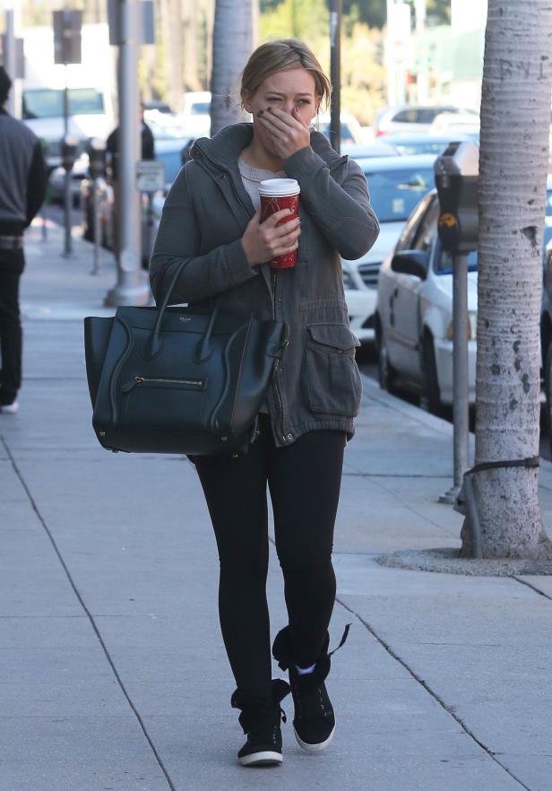Hilary Duff geht mit einem Kaffee in der Hand die Straße entlang.