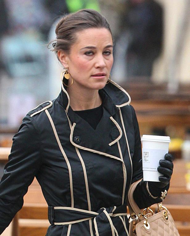 Pippa Middleton mit einem Kaffee in der Hand auf einer Straße.