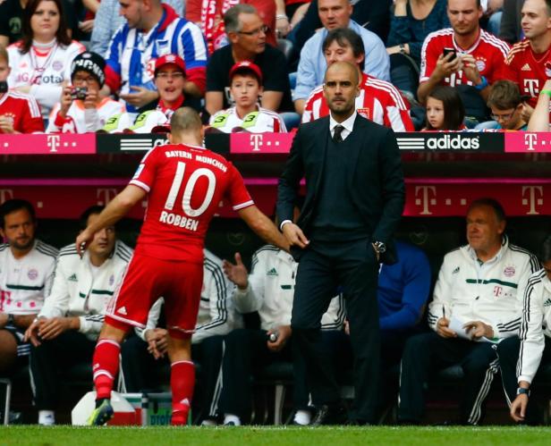 Arjen Robben begrüßt Trainer Pep Guardiola am Spielfeldrand.
