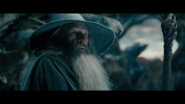 Gandalf mit seinem Stab in einer dunklen Umgebung.