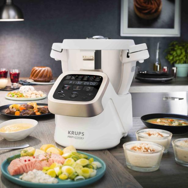 Eine Krups Prep&Cook Küchenmaschine steht umgeben von verschiedenen zubereiteten Gerichten.