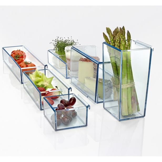 Verschiedene Lebensmittel, darunter Tomaten, Sternfrucht, Käse und Spargel, werden in durchsichtigen Behältern aufbewahrt.