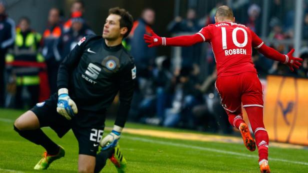 Arjen Robben jubelt auf dem Fußballfeld, während der gegnerische Torwart niedergeschlagen wirkt.