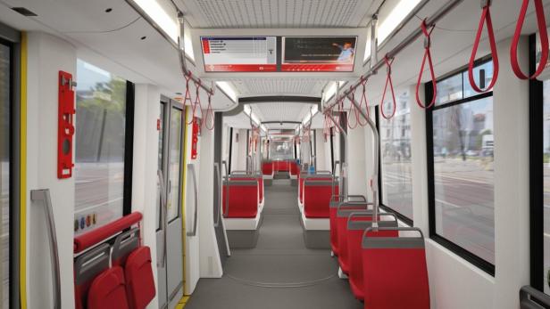 Innenansicht einer modernen Straßenbahn mit roten Sitzen und Haltegriffen.