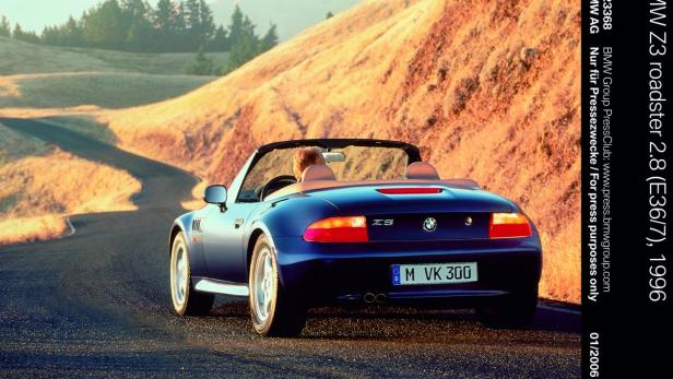 Ein blauer BMW Z3 Roadster fährt auf einer kurvenreichen Straße entlang.