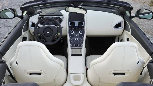 Innenraum eines Aston Martin Cabrios mit hellen Ledersitzen.
