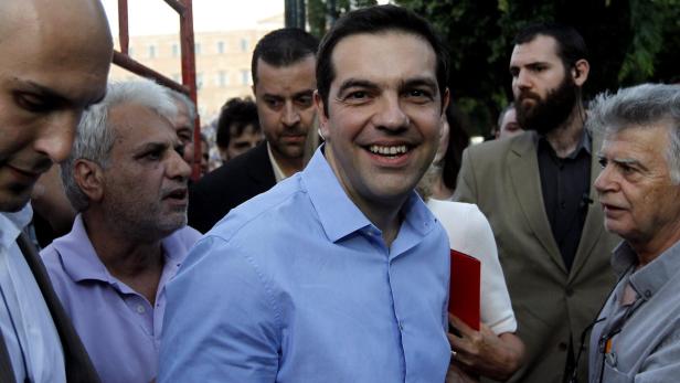 Alexis Tsipras lächelt inmitten einer Menschenmenge.