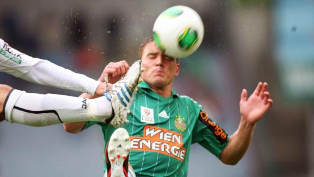 Ein Fußballspieler wird von einem Fußball am Kopf getroffen.