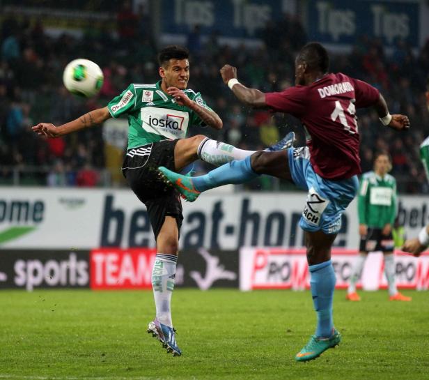 Zwei Fußballspieler kämpfen um den Ball während eines Spiels.