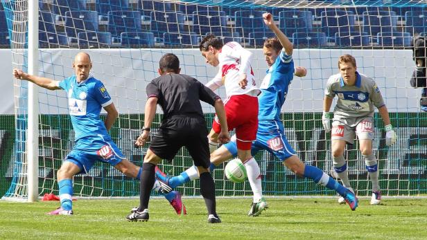 Fußballspieler kämpfen um den Ball vor dem Tor.