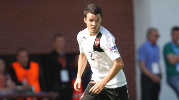 Ein junger Fußballspieler im österreichischen Nationaltrikot auf dem Spielfeld.