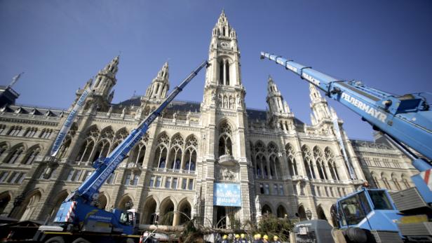 Das Wiener Rathaus wird mit zwei blauen Kränen für eine Veranstaltung vorbereitet.