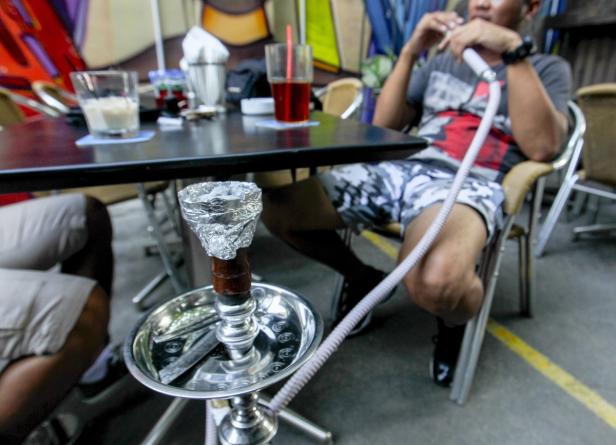 Ein Mann raucht eine Wasserpfeife in einem Café.