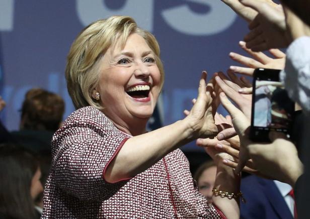 Hillary Clinton lacht und gibt Menschen in der Menge High-Fives.