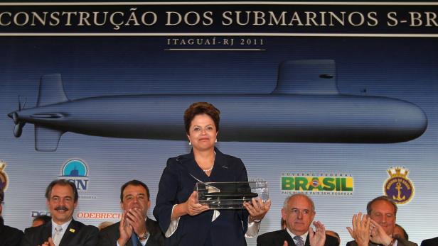 Dilma Rousseff hält ein Modell eines U-Boots vor einer Tafel über den Bau von U-Booten in Itaguaí, Brasilien.