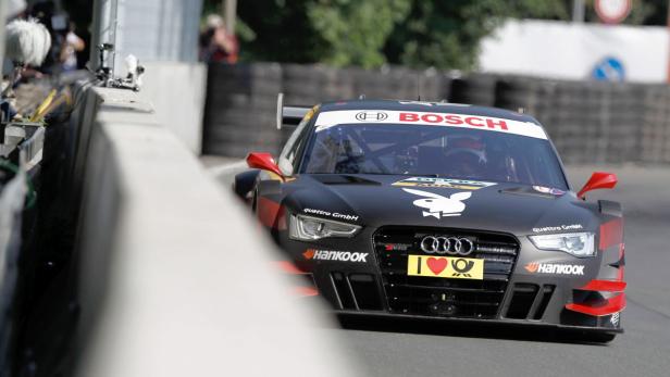 Ein schwarzer Audi-Rennwagen mit Sponsorenaufklebern auf einer Rennstrecke.