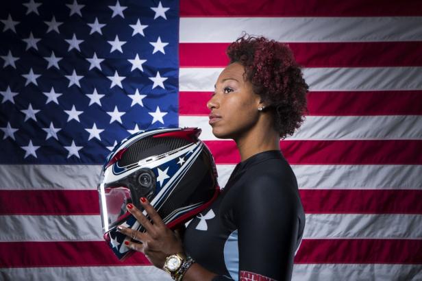 Eine Frau hält einen Helm vor einer US-Flagge.