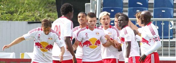 Eine Gruppe von Fußballspielern in weißen und roten Trikots jubelt.