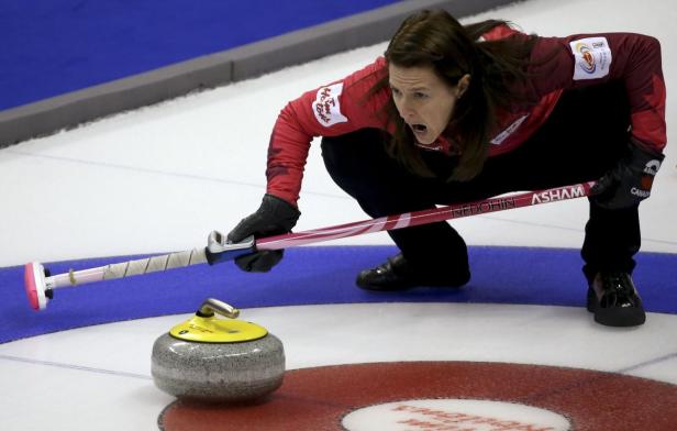 Eine Curlingspielerin kurz vor dem Wurf eines Steins.