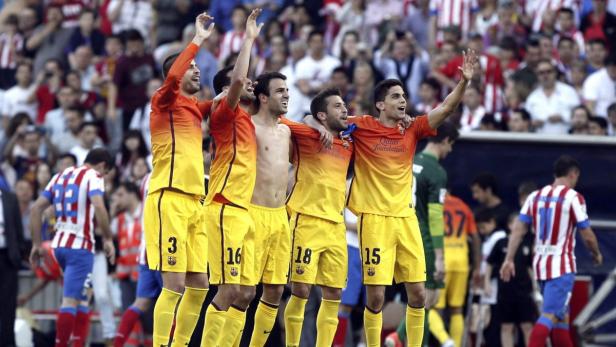 Eine Gruppe Fußballspieler in gelb-orangenen Trikots jubelt vor einer Zuschauermenge.