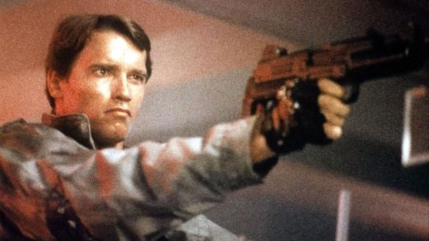 Arnold Schwarzenegger zielt mit einer Waffe in einem Filmstill aus „Terminator“.