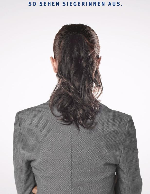 Eine Frau in einem grauen Blazer, von hinten gesehen, mit Handabdrücken auf dem Rücken.