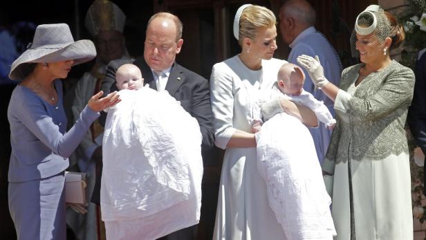 Princess Caroline of Hanover protects the head of Fürst Albert und Fürstin Charlène von Monaco mit ihren Zwillingen bei der Taufe.