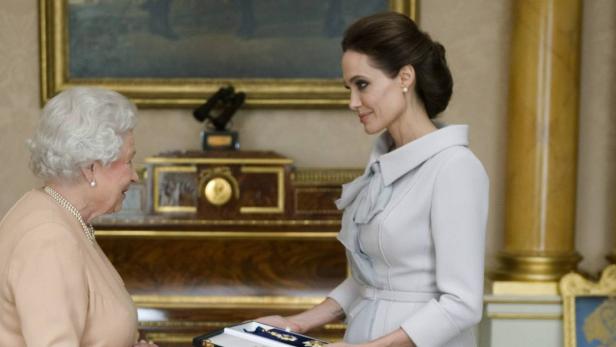 Angelina Jolie überreicht Königin Elisabeth II. eine Auszeichnung.
