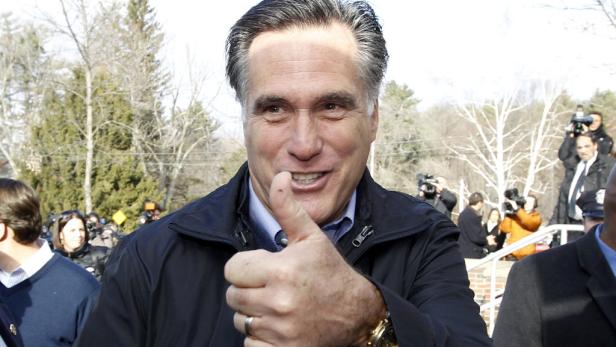 Mitt Romney gibt vor einer Menschenmenge und Kameras einen Daumen nach oben.