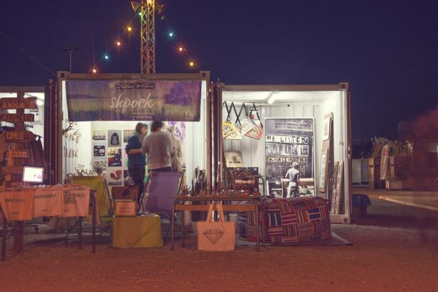 Ein Shpock-Stand auf einem Markt am Abend mit mehreren Personen.
