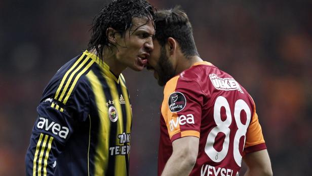 Zwei Fußballspieler stehen sich aggressiv gegenüber, ihre Gesichter nah aneinander.