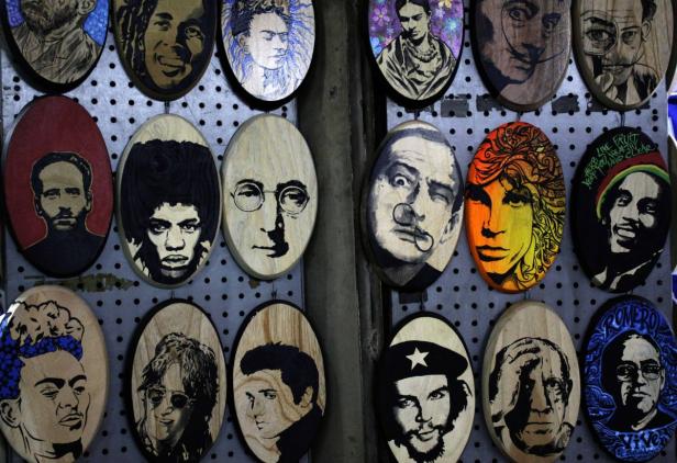 Eine Auswahl an Holzporträts berühmter Persönlichkeiten wie Frida Kahlo, Bob Marley und Che Guevara.