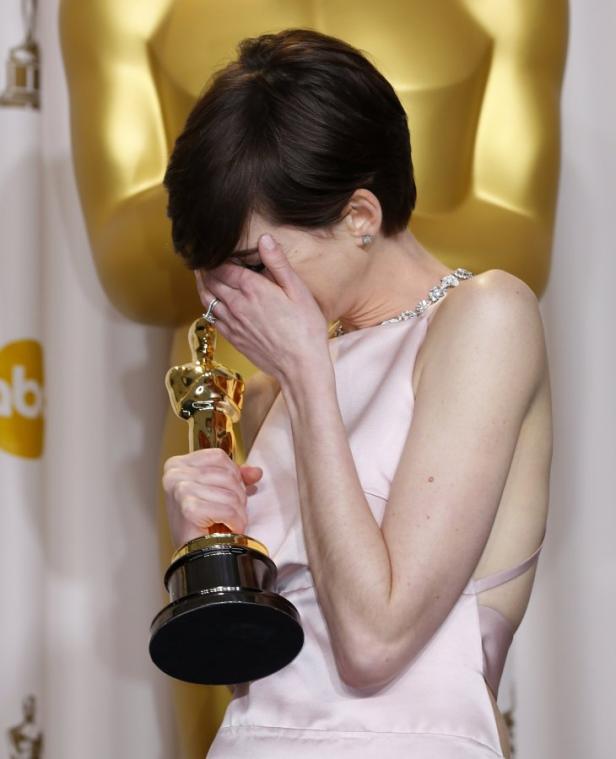 Anne Hathaway hält ihren Oscar gerührt in den Händen.