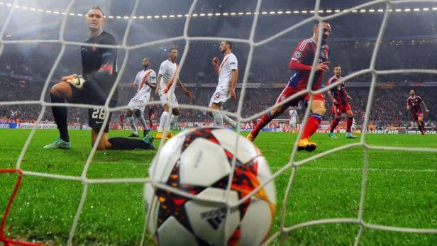 Ein Fußballspiel mit Spielern des FC Bayern München und AS Rom vor einem Tornetz.