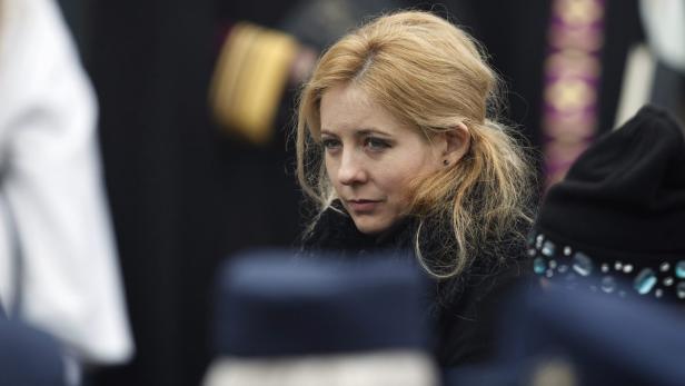 Eine blonde Frau mit ernstem Blick inmitten einer Menschenmenge.