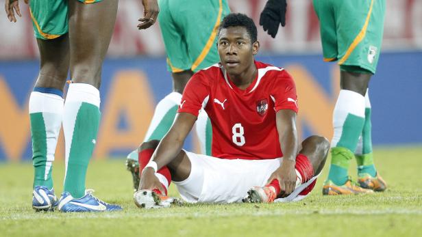 David Alaba sitzt während eines Fußballspiels auf dem Rasen.