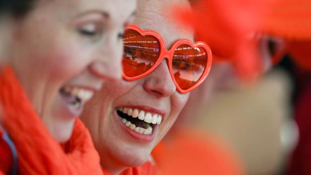 Zwei lachende Frauen, eine davon mit roter Herzchenbrille.