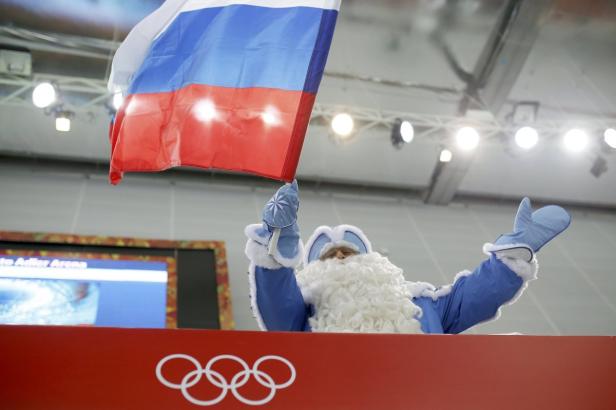 Väterchen Frost schwenkt die russische Flagge vor dem Hintergrund der Olympischen Ringe.