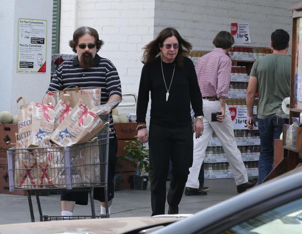 Ozzy Osbourne mit Begleiter und Einkaufswagen vor einem Supermarkt.