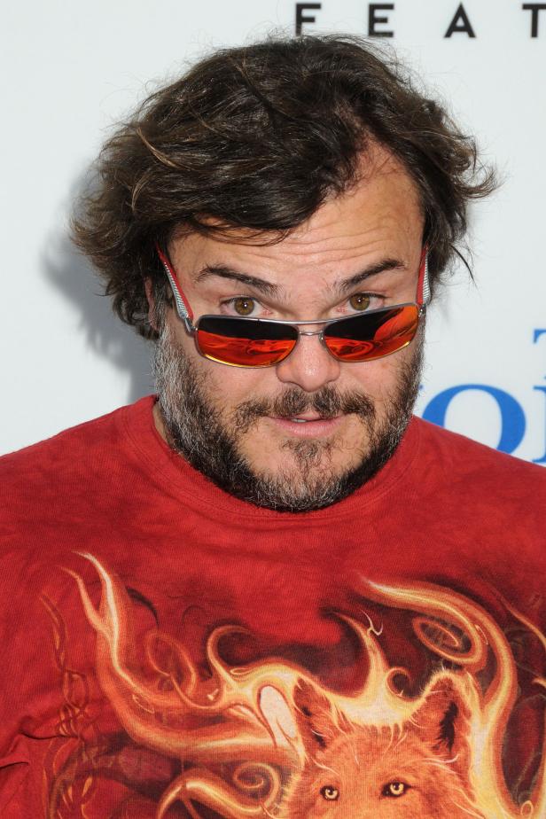 Jack Black mit Bart und Sonnenbrille trägt ein rotes T-Shirt mit Wolfsmotiv.