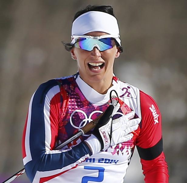 Eine Langläuferin jubelt mit einer Hand auf der Brust.