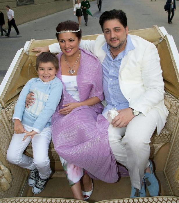 Anna Netrebko, Yusif Eyvazov und ein Kind sitzen in einer Kutsche.