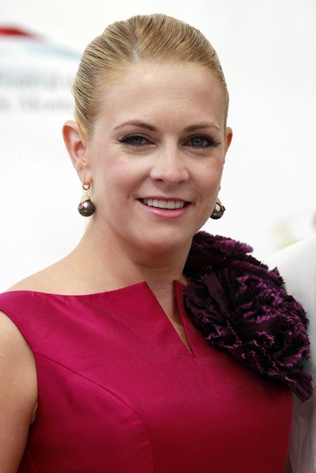 Melissa Joan Hart trägt ein pinkfarbenes Kleid mit einer dunkellila Blume auf der Schulter.