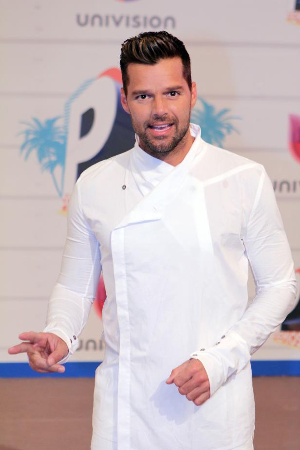 Ricky Martin posiert vor einer Wand mit dem Univision-Logo.