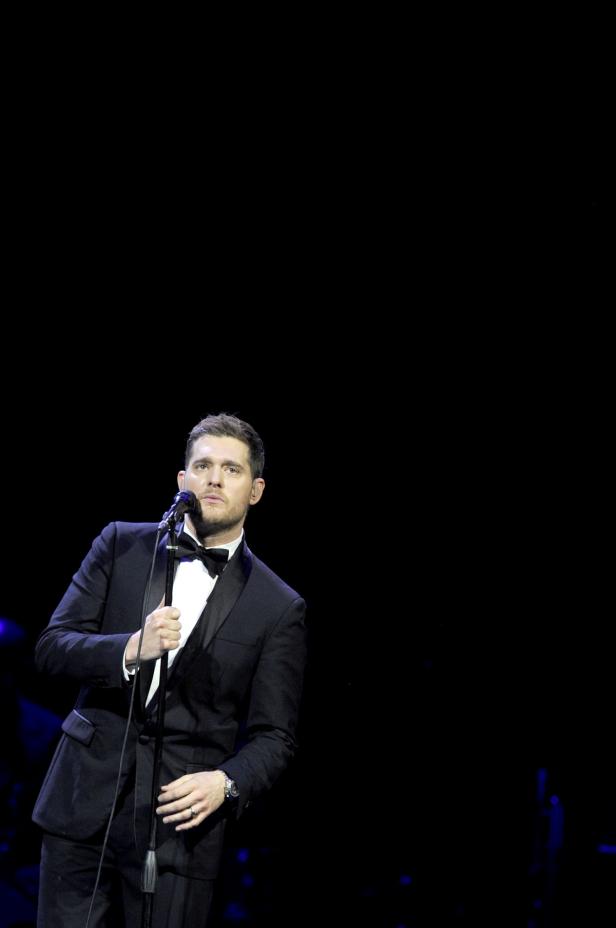 Michael Bublé singt in einem schwarzen Anzug auf der Bühne.